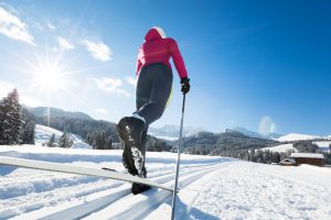 Young woman doing cross-country skiing in dolomite alps.