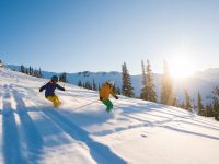 Couple skiing on a sunny powder day