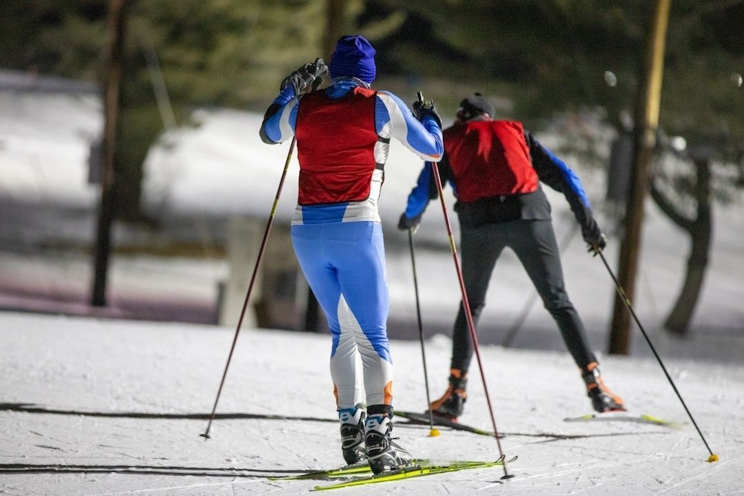 To skiløpere trener diagonalgang i en snødekt motbakke