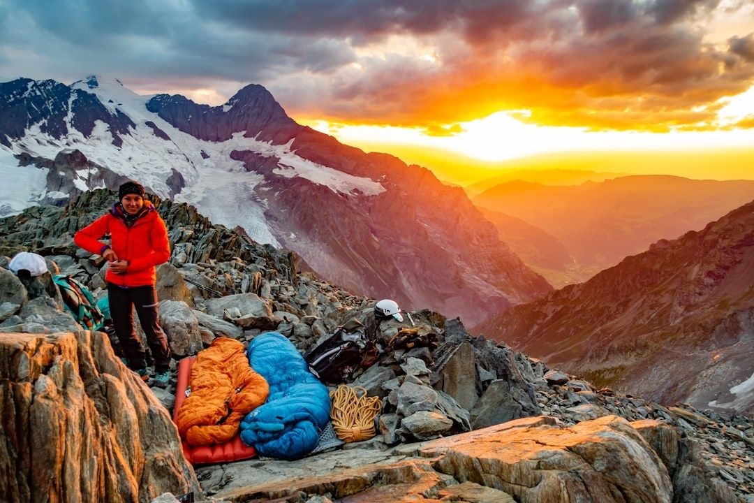 Fjellklatrer med soveposer og turutstyr på en steinete fjellrygg